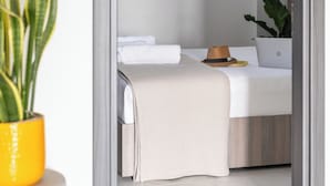 A bedroom with a bed, a laptop, a hat, and a plant. - Sani Gulf I & II (Kassandra)