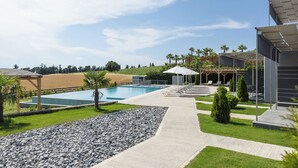A pool area with a clear sky, a pathway, and lounge chairs.