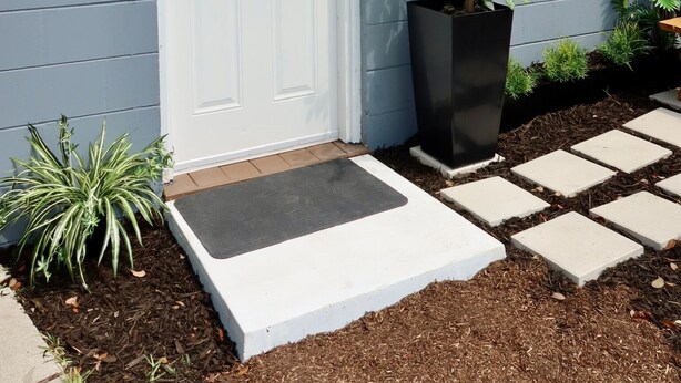 A front door with a wreath, a potted plant, and a stepping stone path leading to the door. - Cozy Private Studio near Ibor & Port (Tampa)