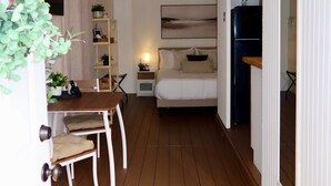 A compact room with a bed, bedside table, and a small desk with a chair. - Cozy Private Studio near Ibor & Port (Tampa)