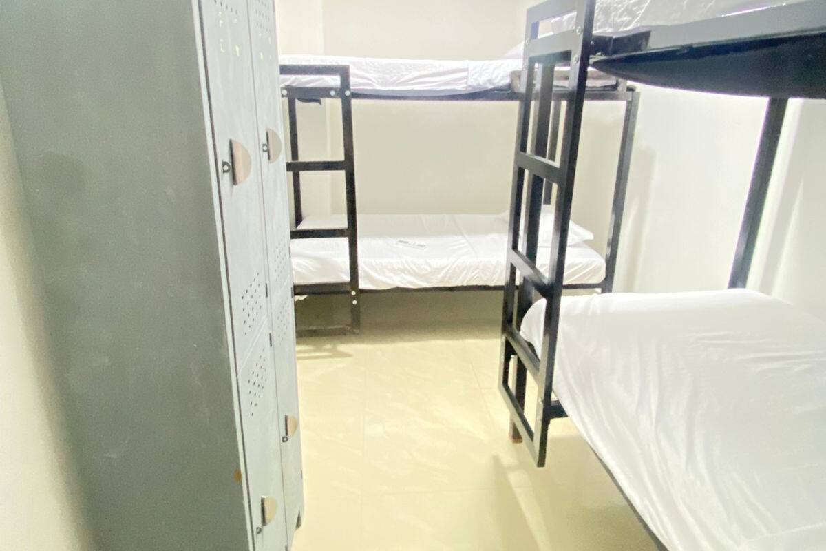 A bunk bed room with a wardrobe and an air conditioning unit.