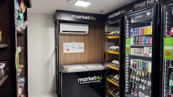 A self-service kiosk with a digital screen and a refrigerated display case with beverages.