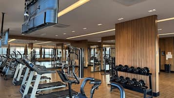 Ett gym med löpband, styrketräningsmaskiner och hantlar.