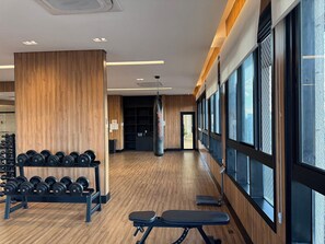 A gym with wooden flooring, weightlifting equipment, and large windows. - Studio recém-construído no coração da Vila Olímpia (São Paulo)