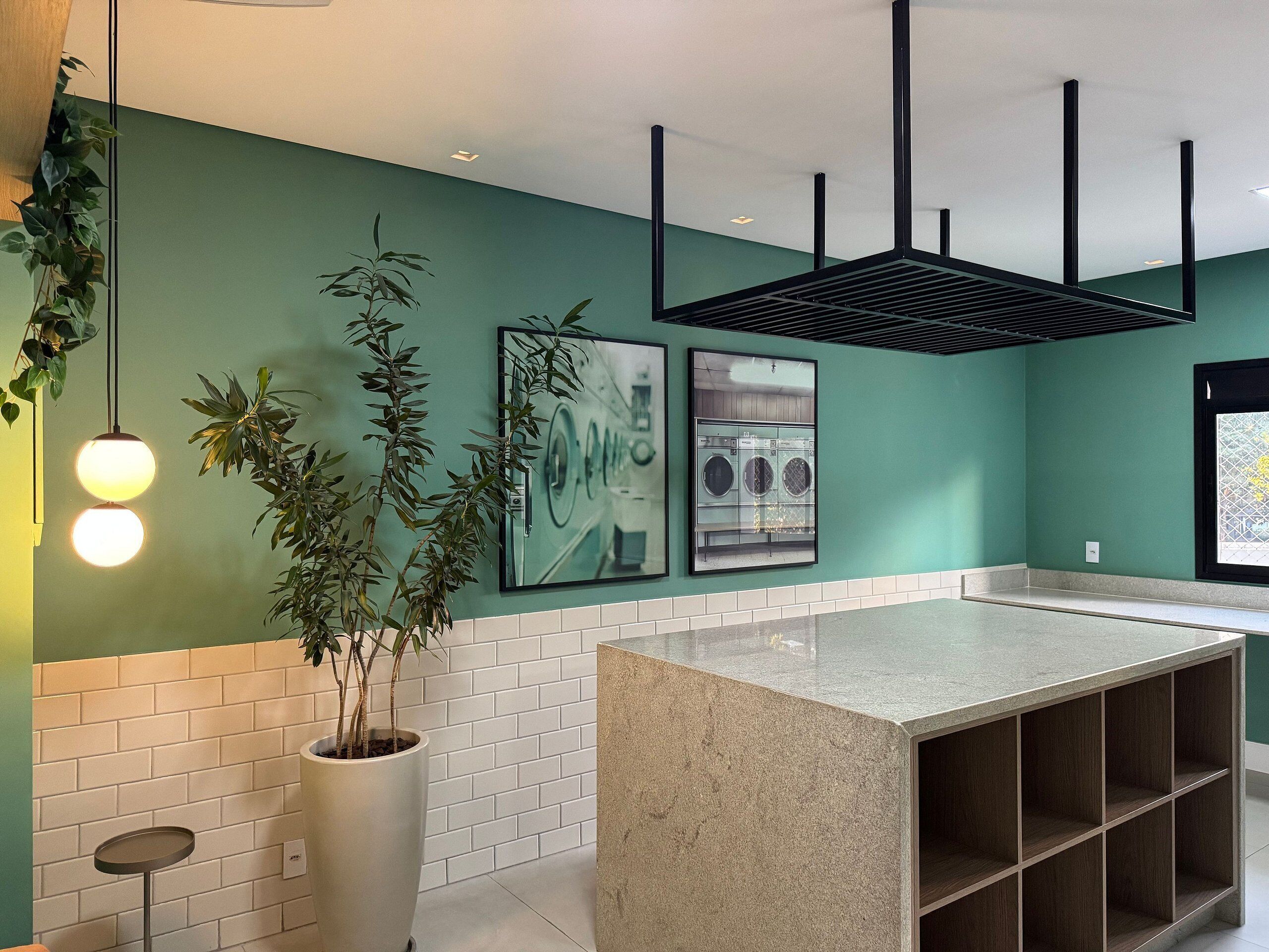 A kitchen with a central island, hanging plants, and a tiled backsplash.