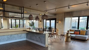 A modern interior with a kitchen island, dining area, and seating space. - Studio recém-construído no coração da Vila Olímpia (São Paulo)