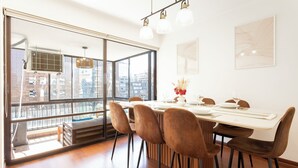 Ein Essbereich mit großem Fenster, einem Tisch für vier Personen und Blick auf die Stadt.