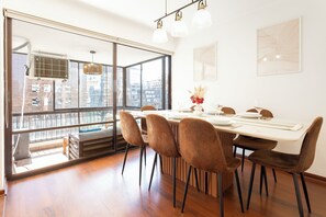 Ein Essbereich mit großem Fenster, einem Tisch für vier Personen und Blick auf die Stadt.