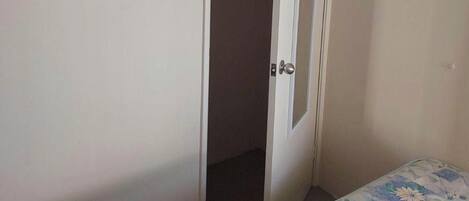 A bedroom with a bed, a closet, and a door.