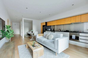Ein modernes Wohnzimmer mit einer Couch, einem Couchtisch und einem Essbereich mit Tisch und Stühlen.
