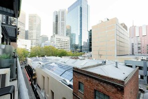 A cityscape with modern high-rise buildings, a mix of residential and commercial structures, and a rooftop with a glass facade. - Newly Refurbished 1 BDR CBD Studio on Liverpool St (Melbourne)
