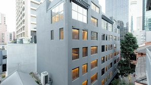 Een modern gebouw met meerdere verdiepingen, grote ramen en een plat dak.