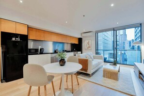 Eine moderne Wohnung mit Küche, Essbereich und Wohnzimmer mit Blick auf die Stadt.