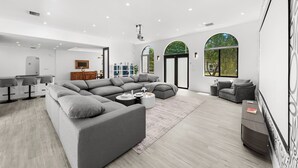 Ein modernes Wohnzimmer mit einer Eckcouch, einem Couchtisch und einem Fernseher.
