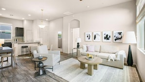 A modern living room with a sofa, two armchairs, a coffee table, and a dining area with a table and chairs. - Landing Furnished Apartments Ocean Springs - Gulf Hills (Ocean Springs)