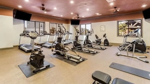 A gym with treadmills, elliptical machines, and stationary bikes arranged in rows. - Landing Furnished Apartments Ocean Springs - Gulf Hills (Ocean Springs)