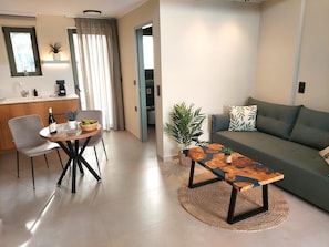 Ein modernes Wohnzimmer mit einer Couch, einem Couchtisch und einem Essbereich mit Stuhl und Tisch.