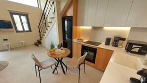 Een moderne keuken met een eethoek, een trap en uitzicht op het buiten.