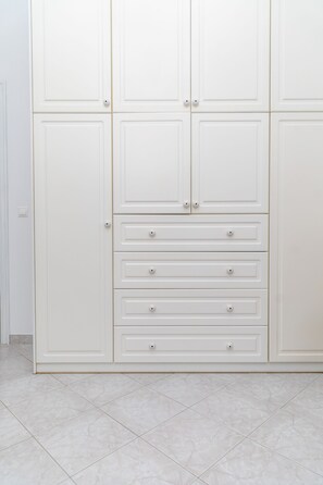 Ein weißer Kleiderschrank mit Schubladen und Türen.