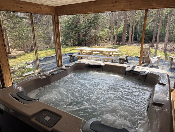 A hot tub with a control panel, surrounded by wooden walls and large windows. - Spacious private modern 4-bedroom house in beautiful natural setting in Brooklin (Brooklin)
