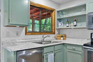 A kitchen with a granite countertop, stainless steel sink, and a window with a view of trees. - Mountain Views + Fire pit | 10 Min to BR/Yoga Room - Holiday Home (Blue Ridge)