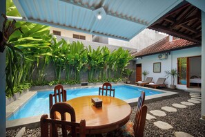 Una piscina al aire libre, sillones reclinables de piscina
