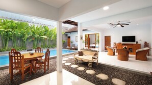 Un interior moderno con piscina, zona de estar y televisor.