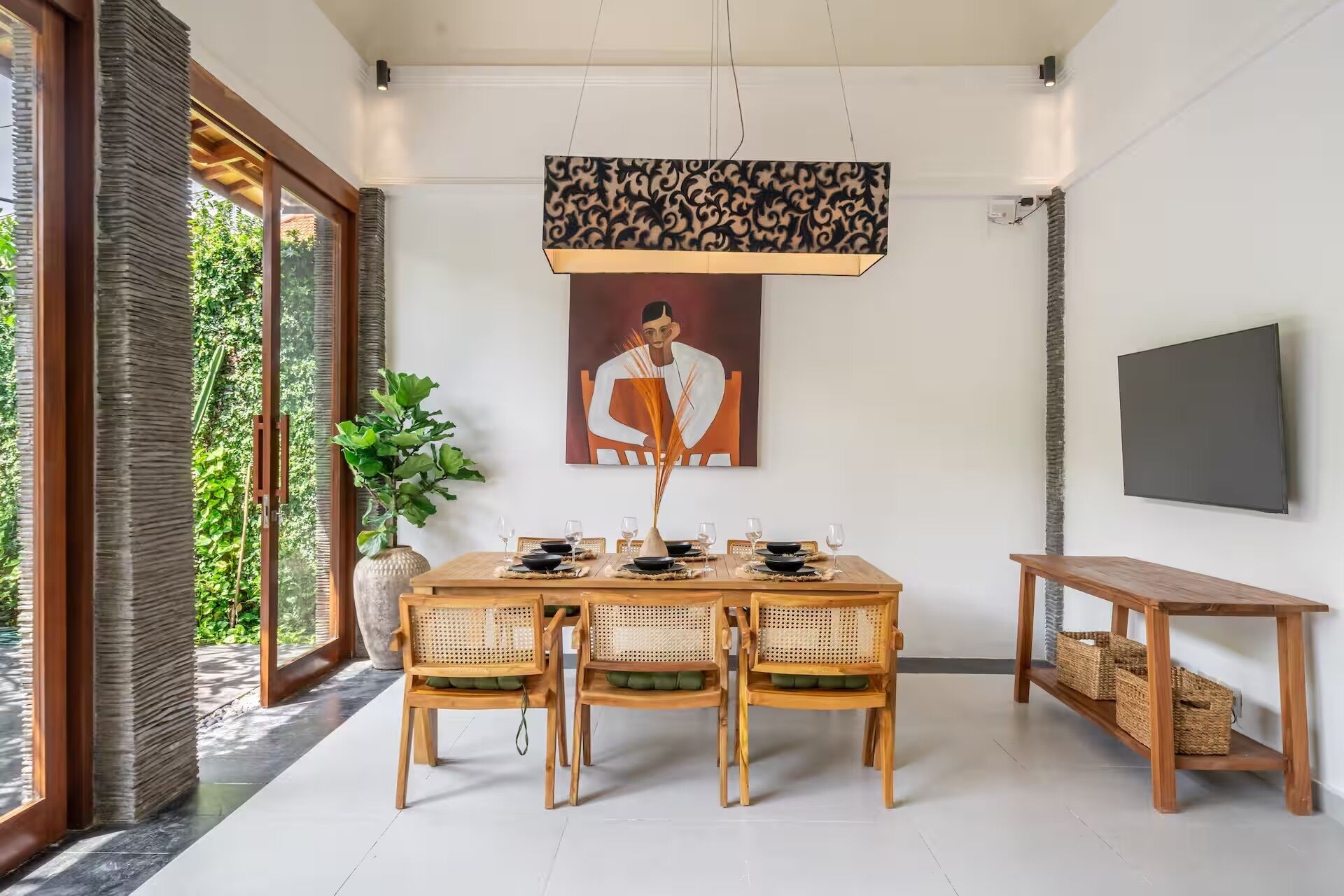 A dining area with a wooden table, four chairs, a vase, and a painting on the wall.