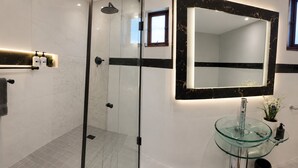 A modern bathroom with a glass-enclosed shower, a glass sink, and a large mirror with a black frame. - Room-tranquil Studio Retreat With Pool a (Westville)