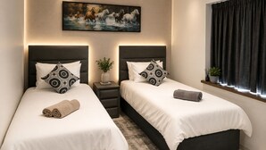 A modern hotel room with two beds, a painting, a window with curtains, and a small plant on the windowsill. - Room-tranquil Studio Retreat With Pool a (Westville)