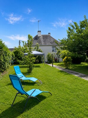 A house with a lawn, two blue lawn chairs, a white umbrella, and a chimney. - Pont-Aven vacation home, ideal for families. Pets welcome! (Pont-Aven)