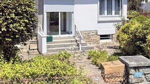 Ein eingeschossiges Haus mit geneigtem Dach, Schornstein und einem kleinen Fenster.