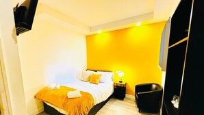 Ein Schlafzimmer mit Bett, Nachttisch und Stuhl.