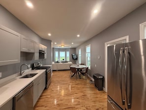 Una cocina moderna con una isla central, electrodomésticos de acero inoxidable y una zona de comedor con vistas.