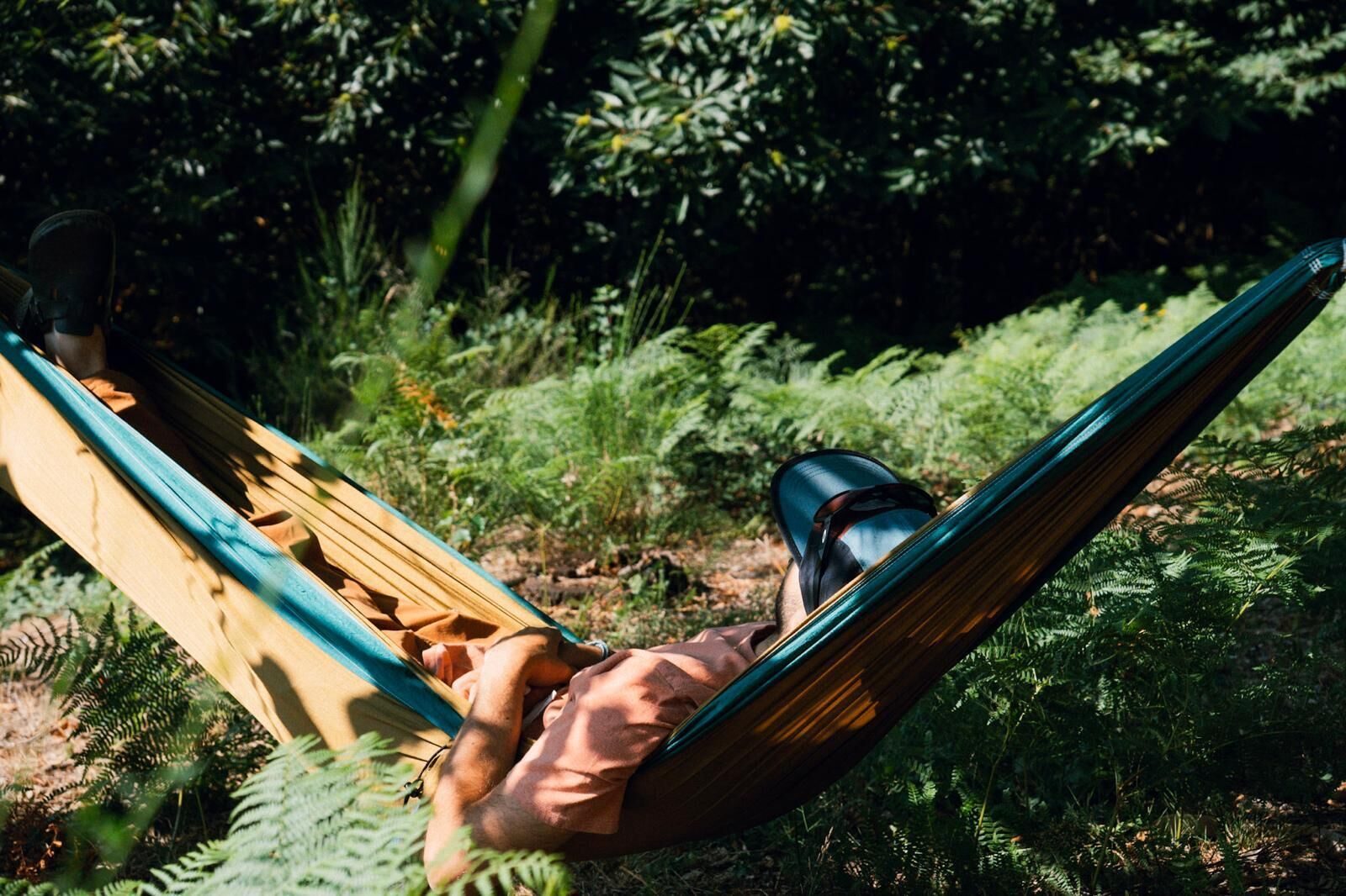 A hammock in a natural setting with dense foliage in the background.