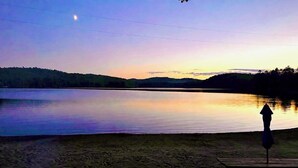A lakeside view with a bench and a picnic table. - Waterfront lake house with private beach and dock with hot  tub on Paradox Lake. (Schroon Lake)