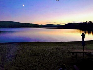 A lakeside view with a bench and a picnic table.