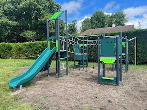 A playground with a slide, climbing structures, and a netted area. - Mobile home in a 4-star campsite (Aureilhan)