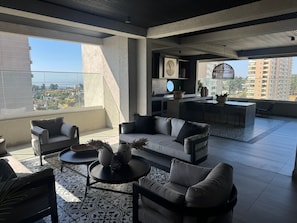 Ein moderner Wohnraum mit Balkon, einer Küchenzeile und einer Sitzecke.