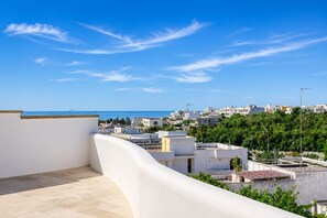 A rooftop terrace with a view of a coastal town, buildings, and greenery. - Ground-Floor One-Bedroom Apartment with Sea-View Balcony in Castro di Lecce (Castro)