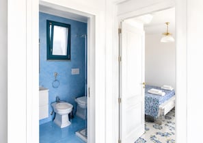 Une salle de bain Ă©quipĂ©e de toilettes, dâun bidet et dâune douche.