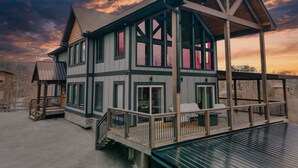 Ein zweistöckiges Haus mit Balkon, Treppe und Terrasse.
