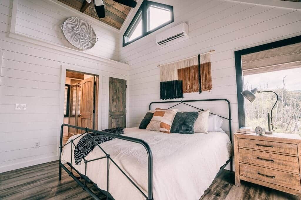 Ein Schlafzimmer mit Bett, Nachttisch und Fenster.