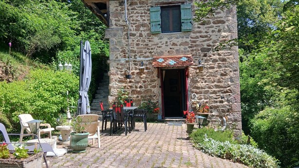 A stone building with a tiled roof, a small porch, and outdoor seating. - An 18th-century tower in the heart of the Haut-Beaujolais region (Deux-Grosnes)