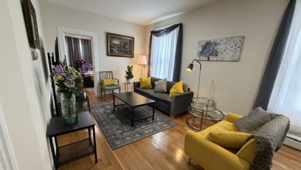 Un salon comprenant un canapé, un fauteuil, une table basse et une lampe.