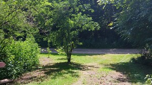 Ein Garten mit einem Weg, einer Bank und einer Metallskulptur.