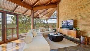 Un'ampia zona giorno con un divano componibile, un tavolino da caffè e una TV su un mobile in legno.