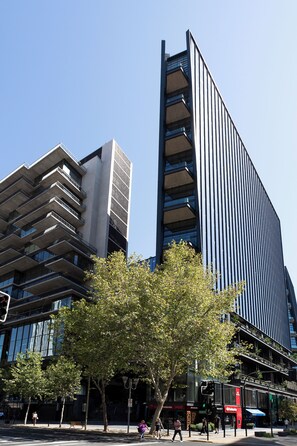 Ein modernes Gebäude mit einem einzigartigen architektonischen Design, das Balkone und große Fenster kombiniert.