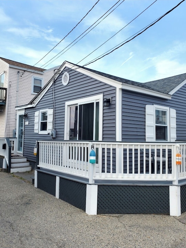 A two-story house with a white porch and a small deck.