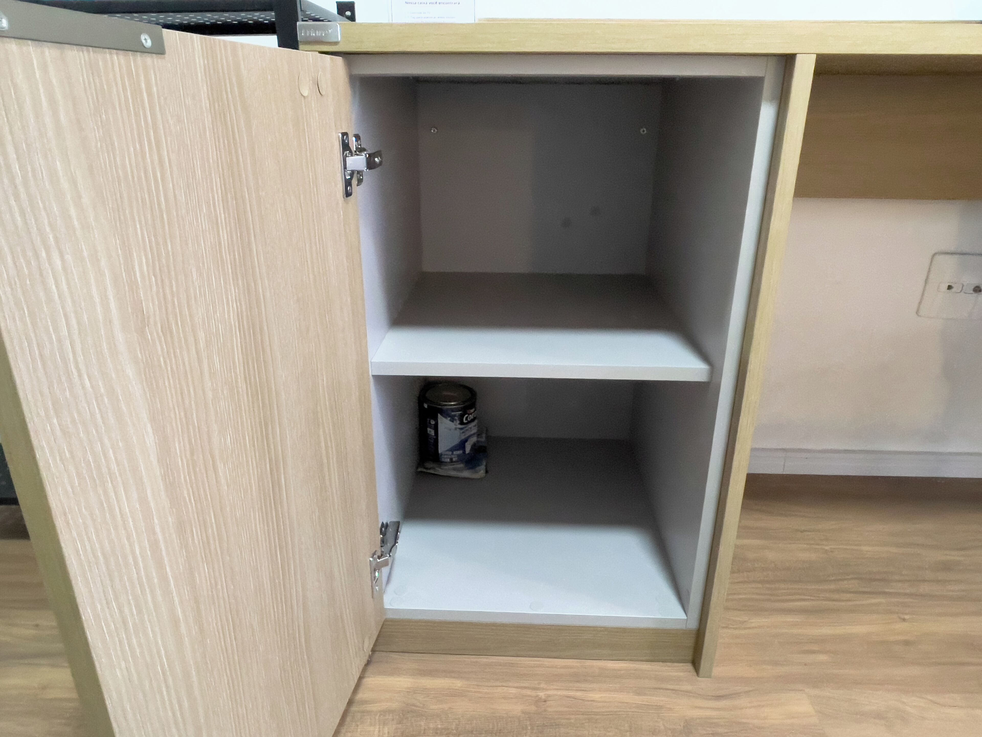 A wooden cabinet with a metal latch, a shelf, and a canister.